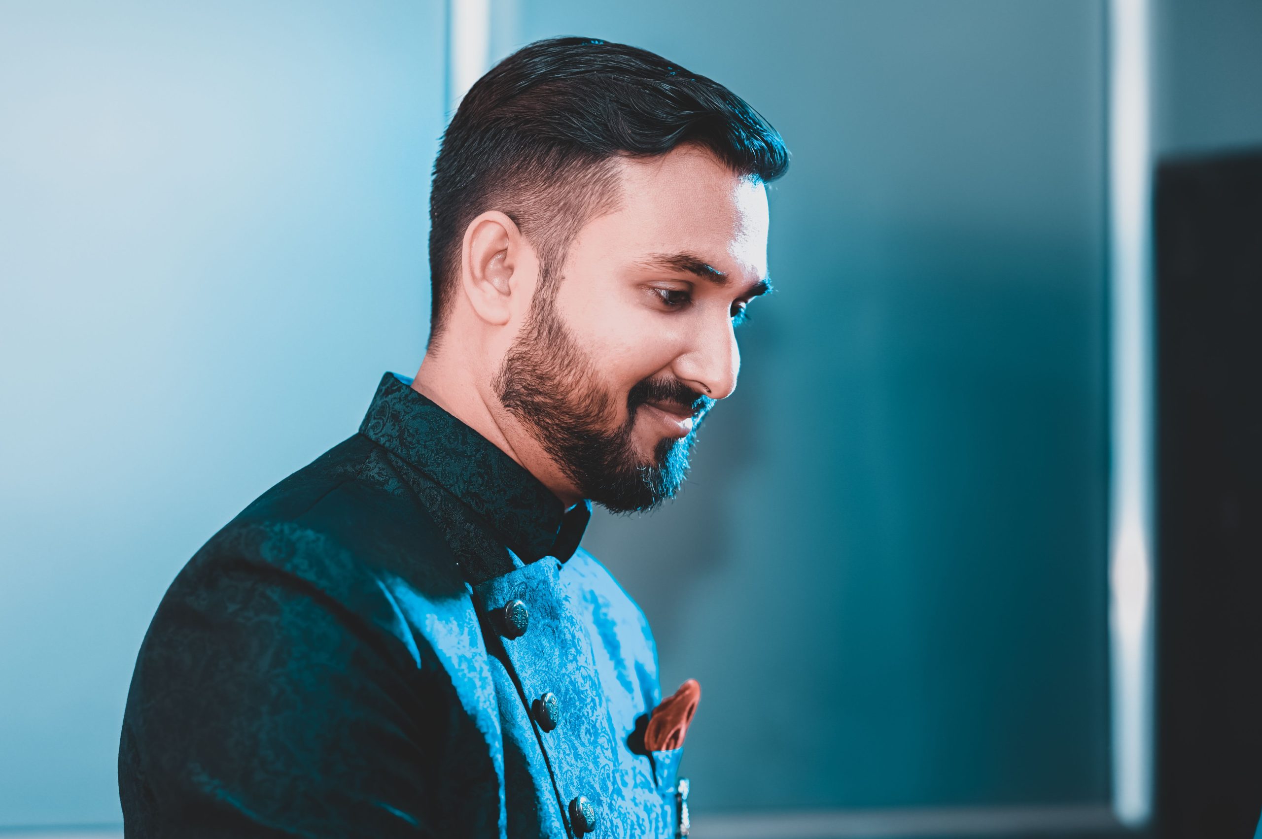Elegant portrait of a bearded man smiling in formal attire, highlighting details and mood.